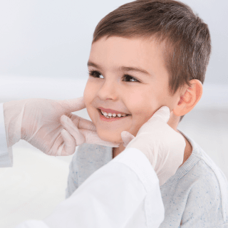 pregled mladeža na licu nasmejanog dečaka - ukoliko je potrebno, lasersko uklanjanje mladeža bezbedno je i za decu