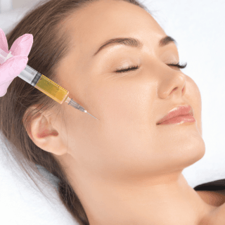 žena zatvorenih očiju leži na stolu u dermatološkoj ordinaciji a pore njenog lica je špric u kome se nalaze egzosomi