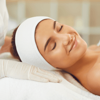 nasmejana žena zatvorenih očiju leži na stolu u dermatološkoj ordinaciji - sprema se za jalupro young eye tretman